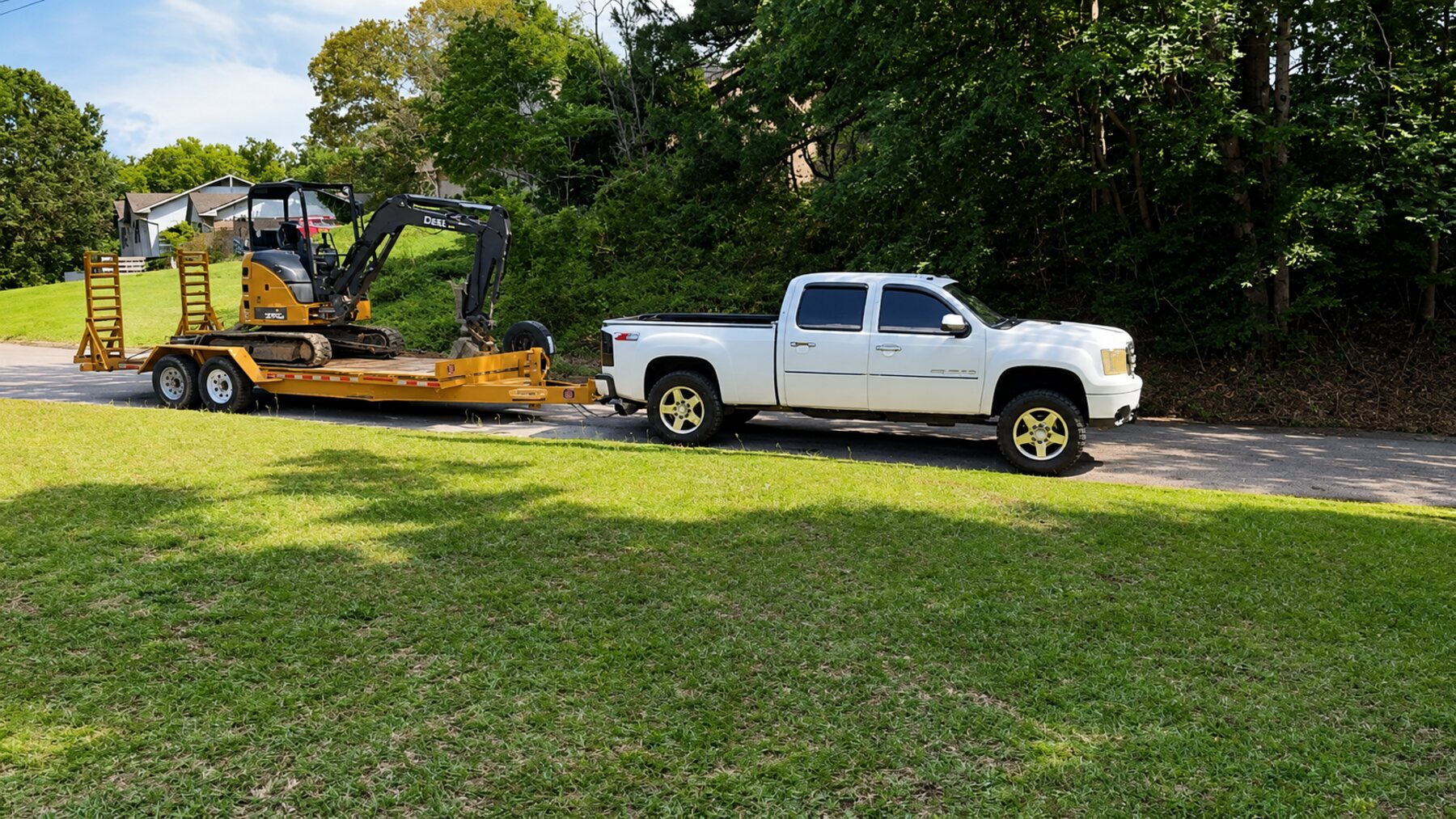 Whitehead Land Services truck and trailer hauling a mini excavator